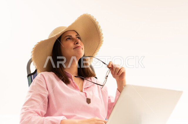 Woman in Straw Hat with Laptop Thinking Outdoors