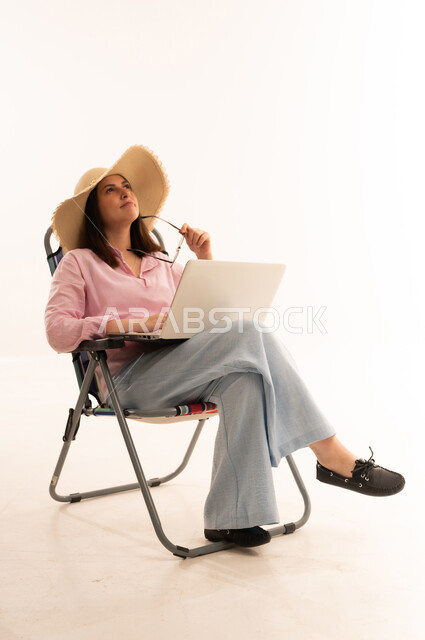 Woman with Laptop Wearing Straw Hat on White Background