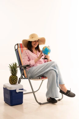 امرأة تمسك كرة أرضية تخطط لإجازة الصيف