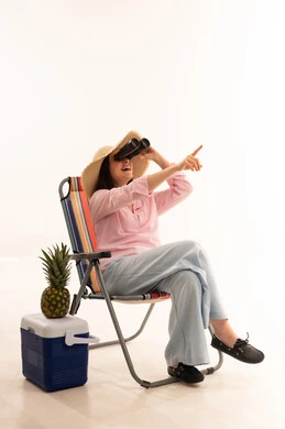 امرأة عربية مع منظار على كرسي الشاطئ