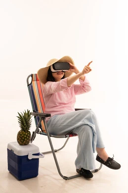 امرأة تستخدم نظارة واقع افتراضي على كرسي شاطئ