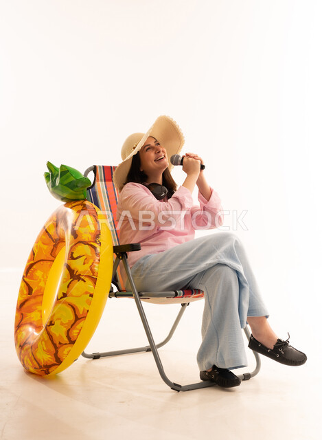 Woman Singing in Beach Chair with Pineapple Inflatable