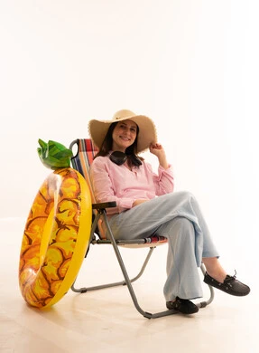 امرأة على كرسي البحر مع مستلزمات الصيف