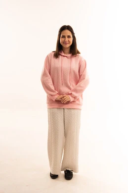 امرأة عربية بسترة وردية أمام خلفية بيضاء