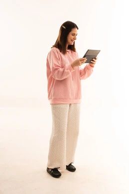 امرأة عربية مبتسمة تستخدم جهاز لوحي في استوديو