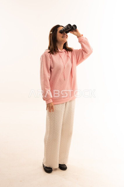 Middle Eastern Woman Looking Through Binoculars in Studio