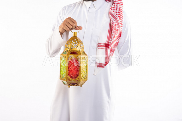 تصوير مقرب ليد رجل عربي سعودي خليجي يرتدي الزي السعودي يحمل فانوس شهر  رمضان, زينه و أجواء رمضانيه, مناسبات دينيه, البهجه والسرور بقدوم رمضان, الإستعداد لشهر رمضان المبارك, تحف وديكورات