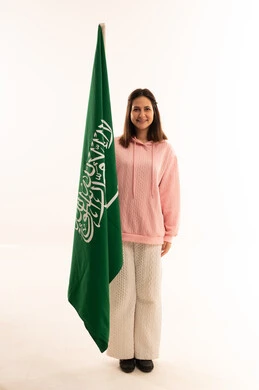 امرأة شابة مع علم السعودية في الاستوديو