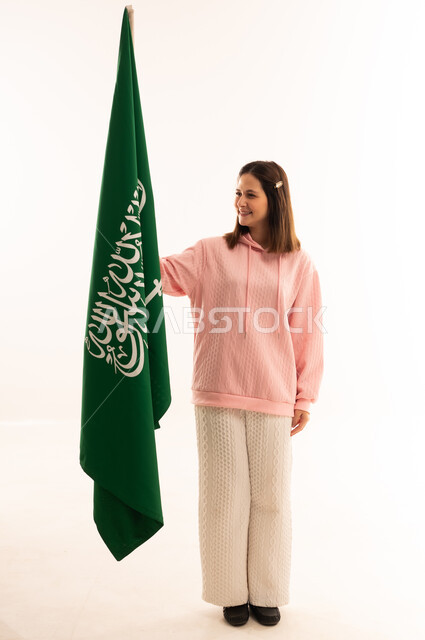 امرأة سعودية تحمل علم المملكة العربية السعودية