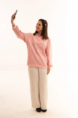 امرأة عربية تلتقط سيلفي بسترة وردية في الاستوديو