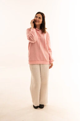 امرأة عربية تتحدث بالهاتف بسترة وردية