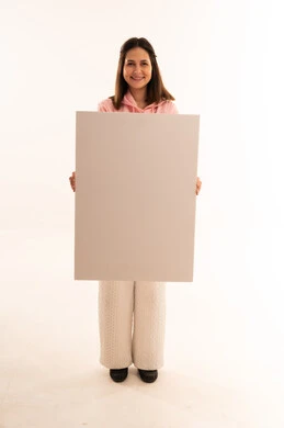 امرأة شابة تحمل لوحة ملصق بيضاء فارغة