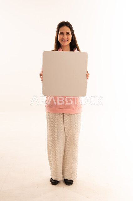 Smiling Arab Woman Holding Blank Signboard in Studio