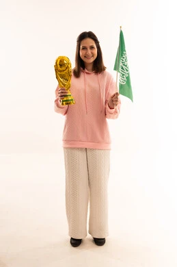 Woman Holding Saudi Flag and Gold World Cup Trophy