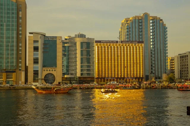 أفق خور دبي مع القوارب التقليدية عند الغروب