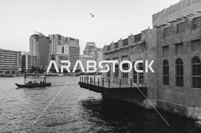 قارب العبرة في خور دبي مع أفق المدينة الحديث