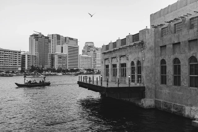 قارب العبرة في خور دبي مع أفق المدينة الحديث