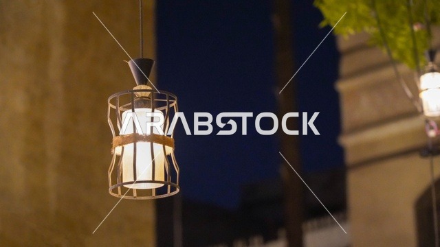 فانوس معدني مزخرف معلق بإضاءة دافئة في الهواء الطلق