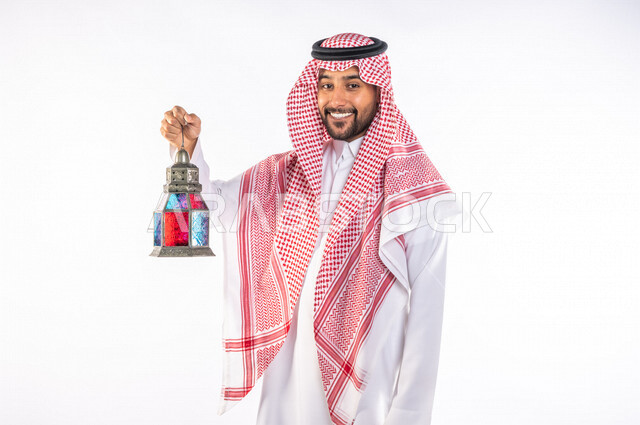 بورتريه لرجل عربي سعودي خليجي يرتدي الزي السعودي يحمل فانوس شهر  رمضان, زينه و أجواء رمضانيه, مناسبات دينيه, البهجه والسرور بقدوم رمضان, الإستعداد لشهر رمضان المبارك, تحف وديكورات