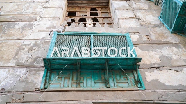 نافذة خشبية تقليدية وقطة على واجهة حجرية