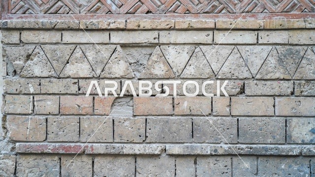 جدار من الطوب القديم بنقوش هندسية حجرية تقليدية
