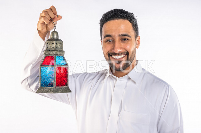بورتريه لرجل عربي سعودي خليجي يرتدي الزي السعودي يحمل فانوس شهر  رمضان, زينه و أجواء رمضانيه, مناسبات دينيه, البهجه والسرور بقدوم رمضان, الإستعداد لشهر رمضان المبارك, تحف وديكورات