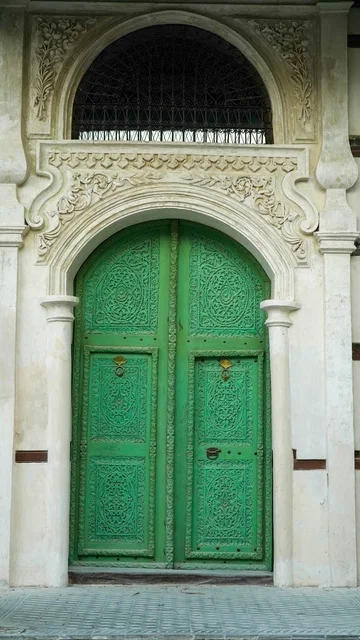 باب أخضر تقليدي مزخرف مع قوس حجري منحوت