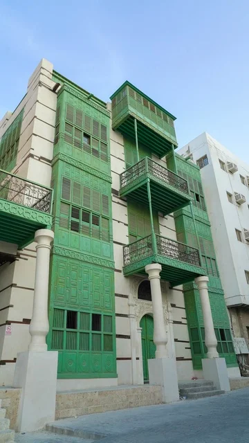 مبنى حجازي تقليدي مع رواشين خضراء في جدة التاريخية