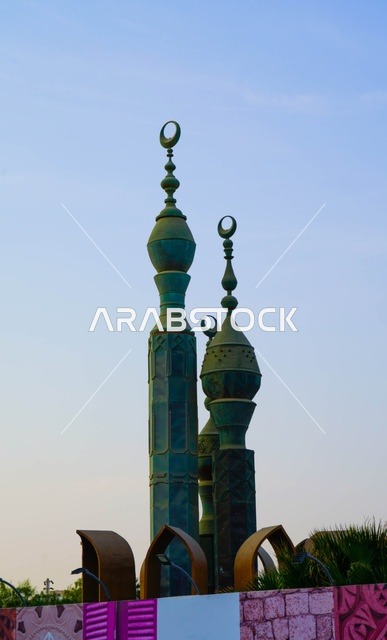 مآذن مسجد خضراء مع أهلة إسلامية تحت السماء