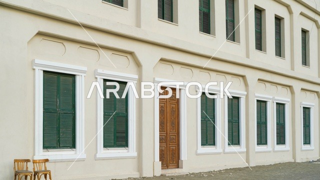 واجهة مبنى تقليدي مع نوافذ خضراء وباب خشبي