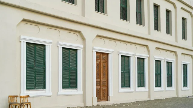 واجهة مبنى تقليدي مع نوافذ خضراء وباب خشبي