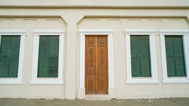 واجهة مبنى تقليدي مع باب خشبي ونوافذ خضراء