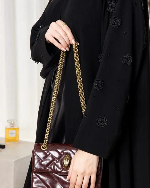 امرأة سعودية بعباية سوداء وحقيبة يد فاخرة