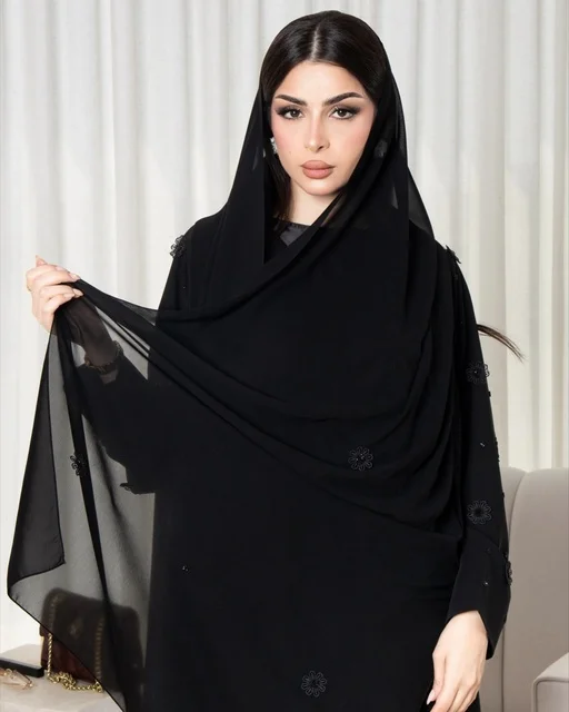 امرأة سعودية بعباءة وشيلة سوداء أنيقة