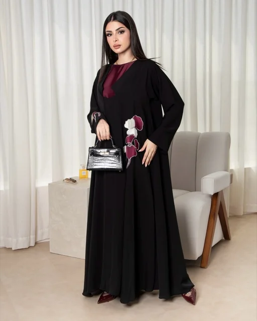 امرأة سعودية بعباءة سوداء عصرية وحقيبة يد