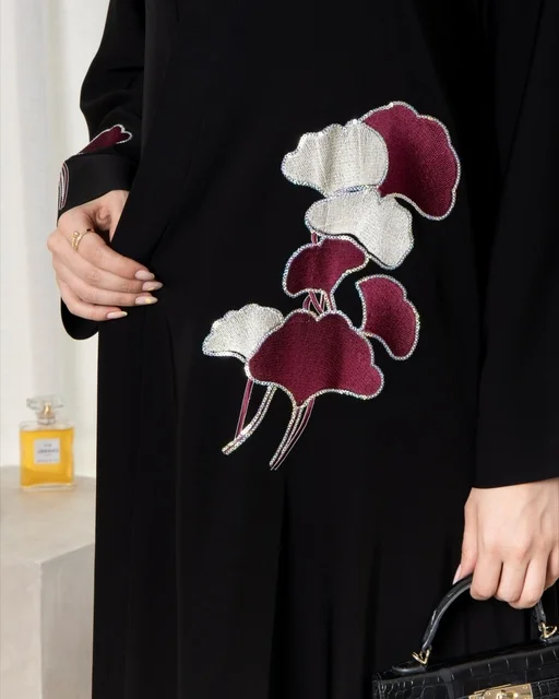 امرأة سعودية بعباءة سوداء مطرزة بتصميم عصري