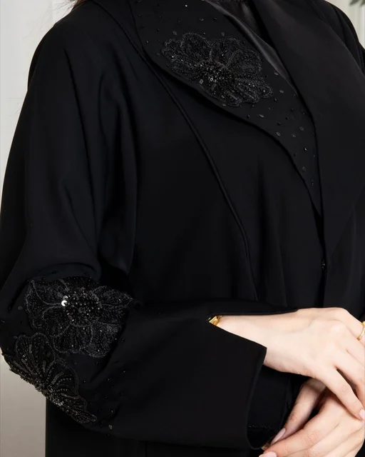 عباءة سوداء عصرية بتطريز زهور دقيق لامرأة سعودية