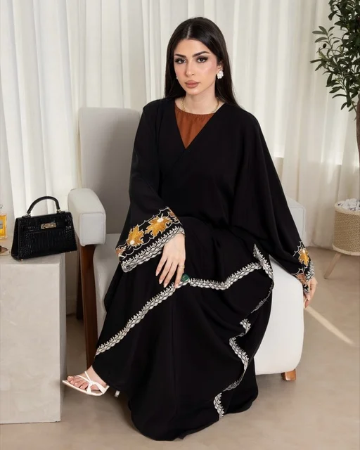 امرأة سعودية بعباية سوداء عصرية تجلس على كرسي