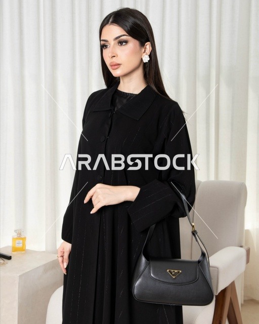 امرأة سعودية بعباءة سوداء عصرية وحقيبة يد
