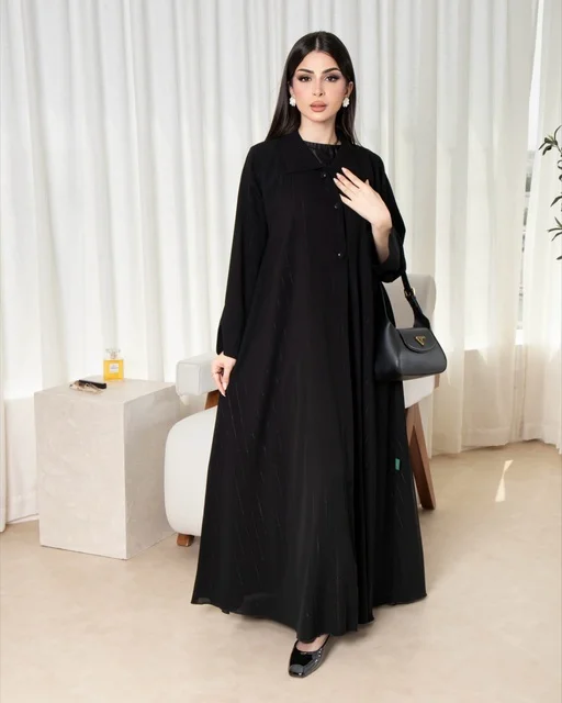 امرأة سعودية بعباءة سوداء عصرية وحقيبة يد