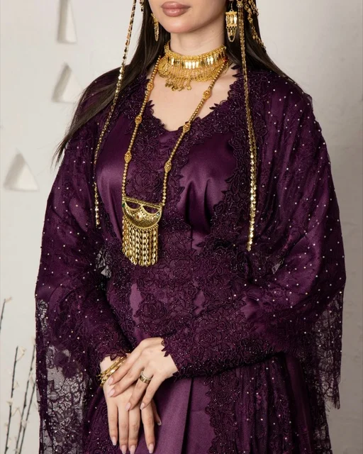 امرأة سعودية بزي تراثي أرجواني ومجوهرات ذهبية
