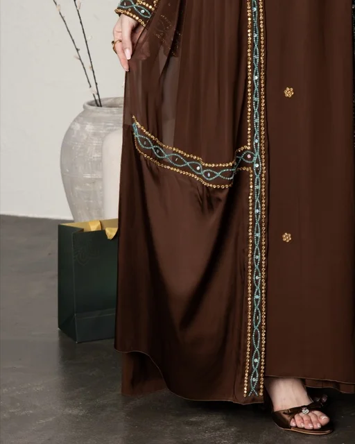 امرأة سعودية بعباءة بنية مطرزة لقطة قريبة