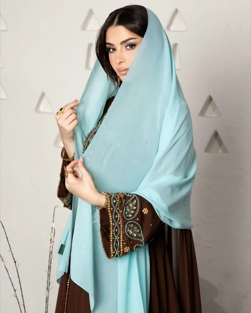 امرأة سعودية بعباءة عصرية وشيلة زرقاء