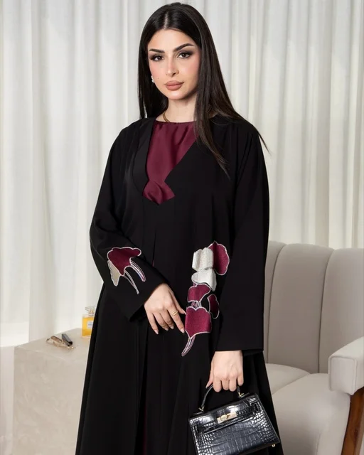 امرأة سعودية بعباءة سوداء عصرية وحقيبة يد