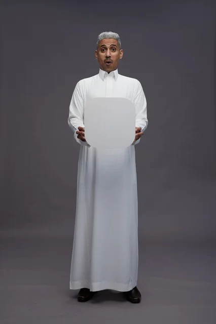 رجل سعودي مندهش يمسك لوحة بيضاء فارغة
