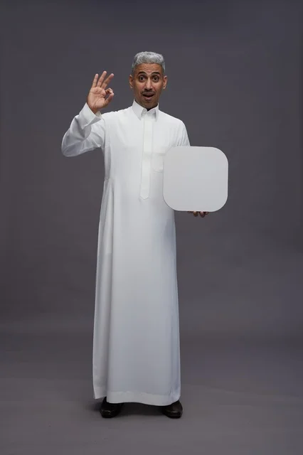 رجل سعودي بالثوب يحمل لوحة بيضاء فارغة