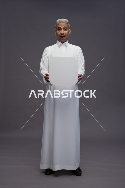 رجل سعودي بالثوب الأبيض يحمل لوحة مربعة فارغة