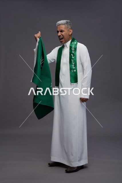 رجل سعودي يحمل العلم الوطني في احتفال