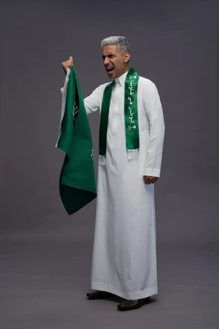 رجل سعودي يحمل العلم الوطني في احتفال