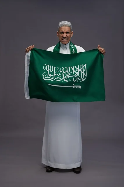 رجل سعودي يحمل العلم الوطني في استوديو